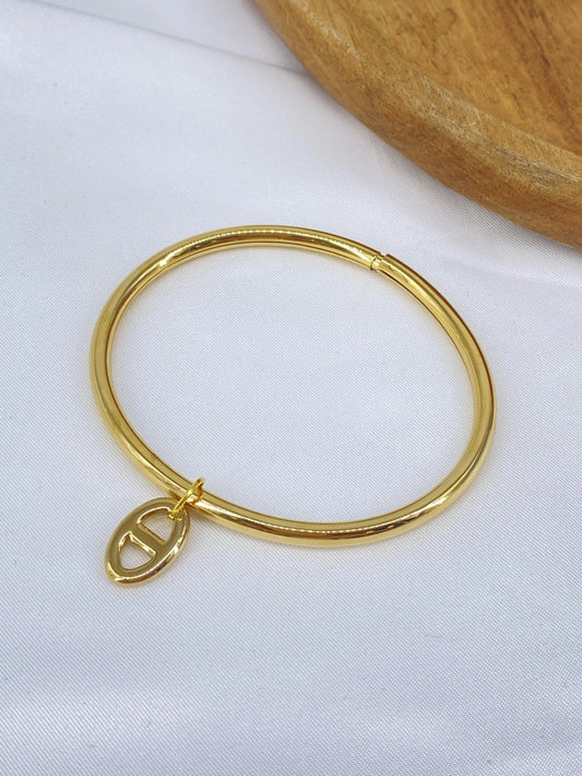 Gold bangle with charm
